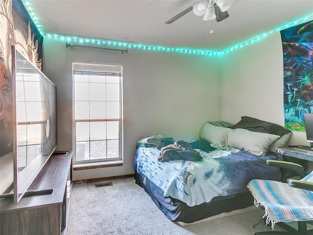 carpeted bedroom with multiple windows and ceiling fan