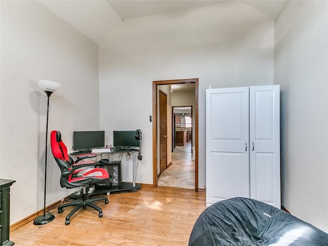 office space with vaulted ceiling and light wood-type flooring