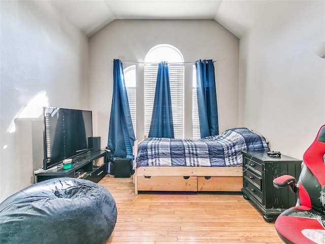 bedroom featuring light hardwood / wood-style floors and vaulted ceiling