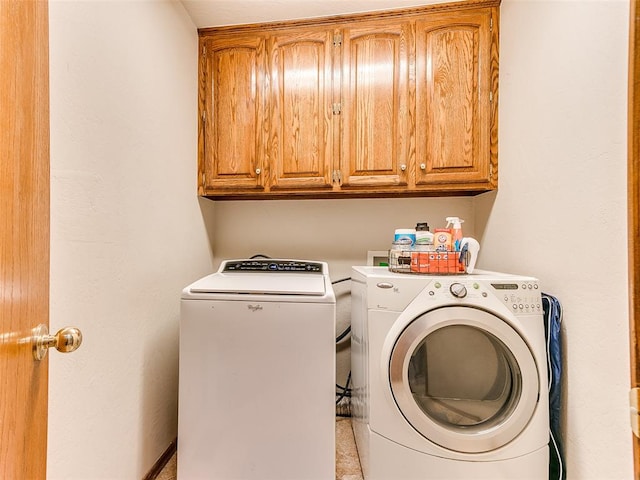 laundry area featuring cabinets, independent washer and dryer, and light tile patterned floors