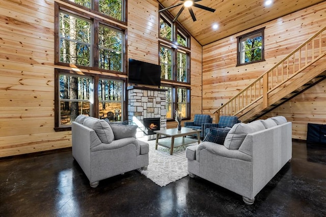 living room featuring a stone fireplace, high vaulted ceiling, wooden walls, and wood ceiling