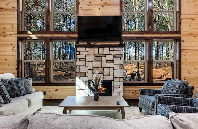 living room with hardwood / wood-style flooring, wood walls, and a fireplace