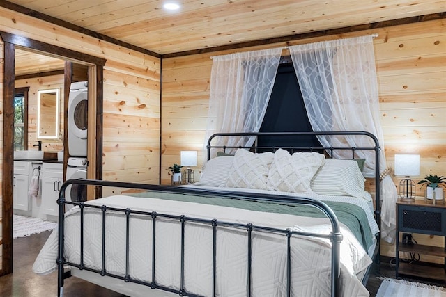 bedroom with wooden ceiling, stacked washer / dryer, and wooden walls