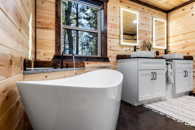 bathroom with wood walls, a washtub, and vanity