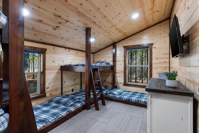 bedroom with wooden ceiling, lofted ceiling, and wood walls