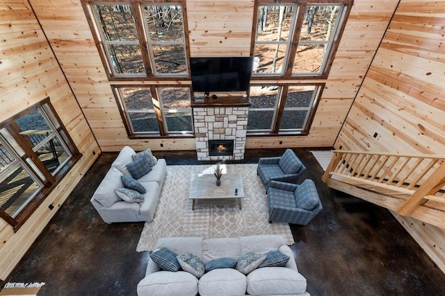 living room with a fireplace and wood walls