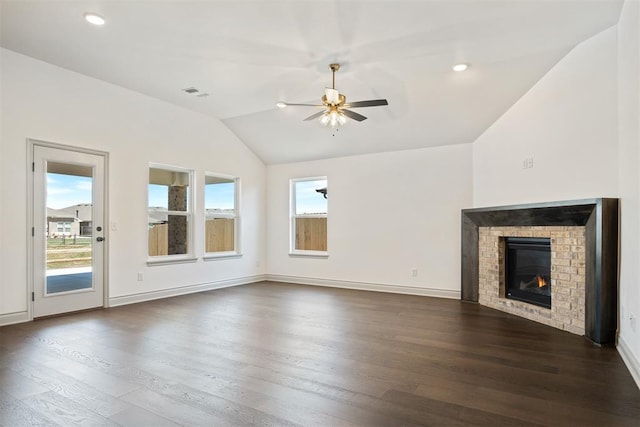 unfurnished living room featuring ceiling fan, dark hardwood / wood-style flooring, vaulted ceiling, and a brick fireplace