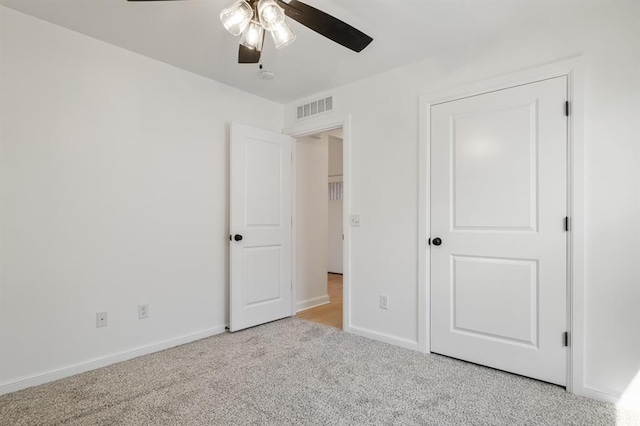 unfurnished bedroom with ceiling fan and light colored carpet