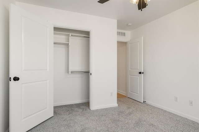 unfurnished bedroom featuring a closet, light colored carpet, and ceiling fan