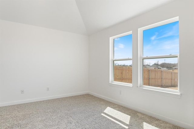 carpeted empty room featuring lofted ceiling