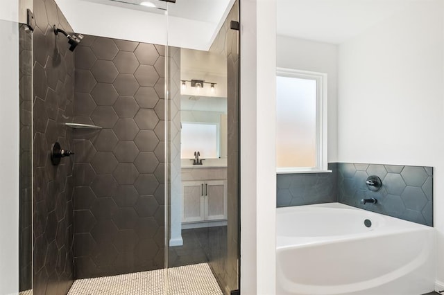 bathroom with vanity and shower with separate bathtub