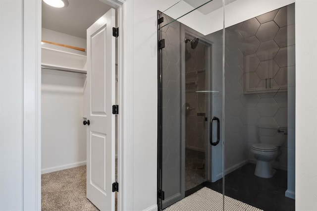 bathroom with a shower with door and toilet