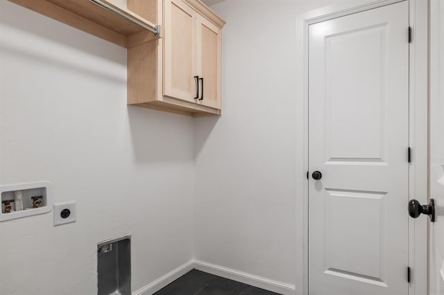 washroom with washer hookup, hookup for an electric dryer, cabinets, and dark tile patterned flooring