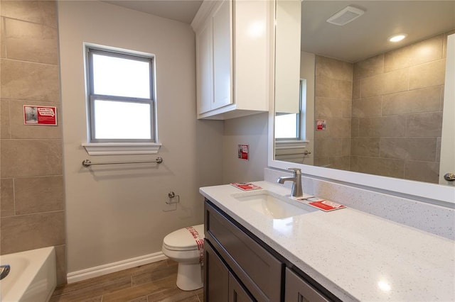 bathroom with plenty of natural light, vanity, and toilet