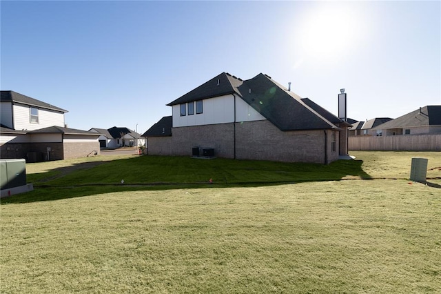 back of house featuring central AC and a lawn