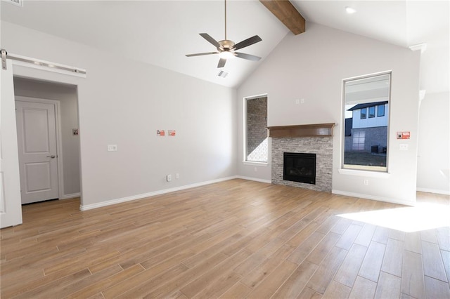 unfurnished living room with high vaulted ceiling, ceiling fan, beam ceiling, a fireplace, and light hardwood / wood-style floors