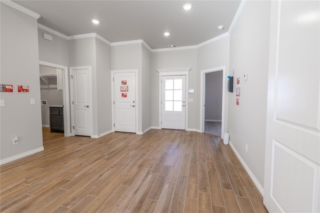 foyer featuring ornamental molding and light hardwood / wood-style flooring