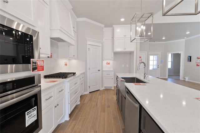 kitchen featuring decorative light fixtures, white cabinetry, and stainless steel appliances