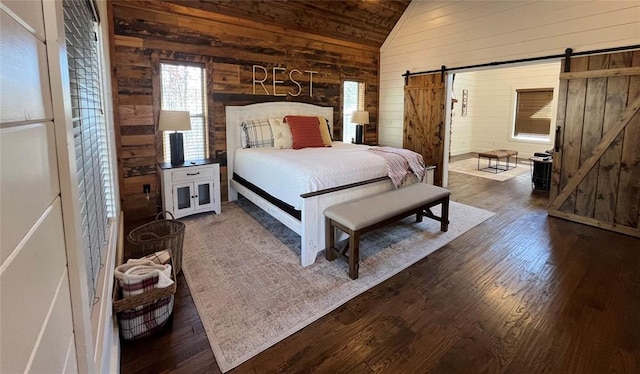 bedroom featuring dark hardwood / wood-style flooring, a barn door, vaulted ceiling, and wood walls