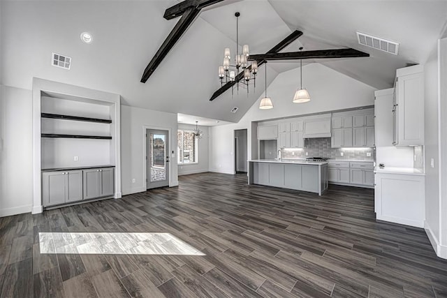 kitchen with a notable chandelier, dark hardwood / wood-style floors, beam ceiling, and decorative light fixtures