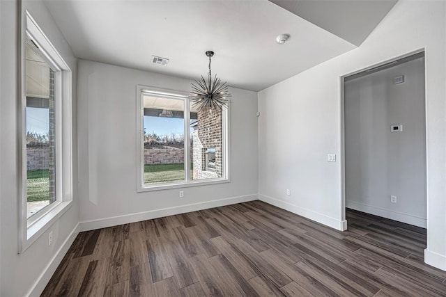 unfurnished dining area with dark wood-type flooring and a notable chandelier