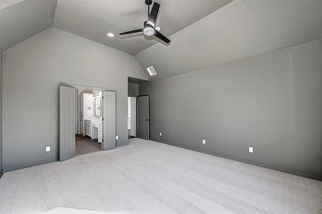 unfurnished bedroom featuring connected bathroom, ceiling fan, lofted ceiling, and dark colored carpet