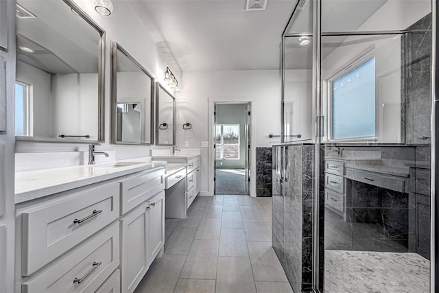 bathroom with vanity, tile walls, and a shower with shower door