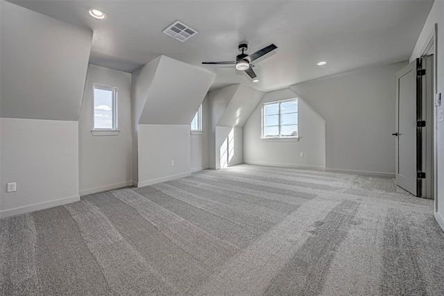 bonus room featuring light colored carpet, plenty of natural light, and ceiling fan