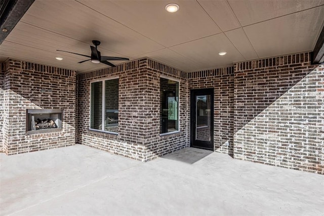 view of patio featuring ceiling fan and an outdoor brick fireplace