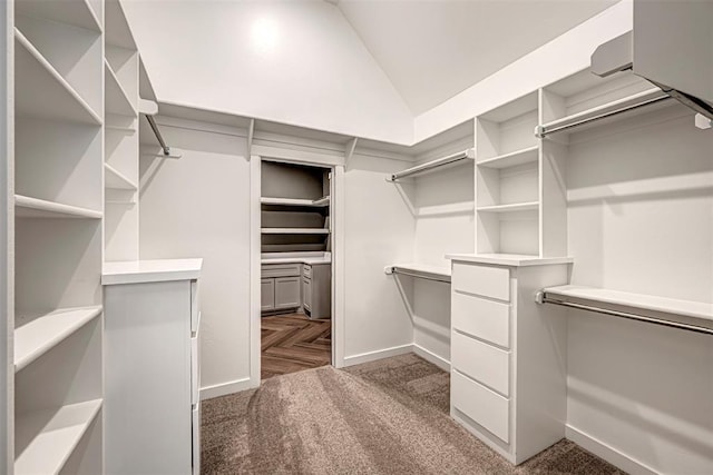 spacious closet with dark carpet and lofted ceiling