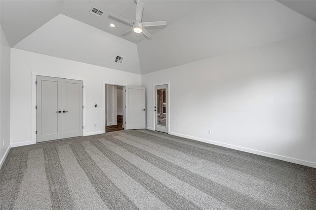 unfurnished bedroom with carpet, ceiling fan, and high vaulted ceiling