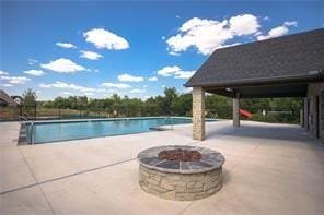 view of swimming pool with a patio and a fire pit