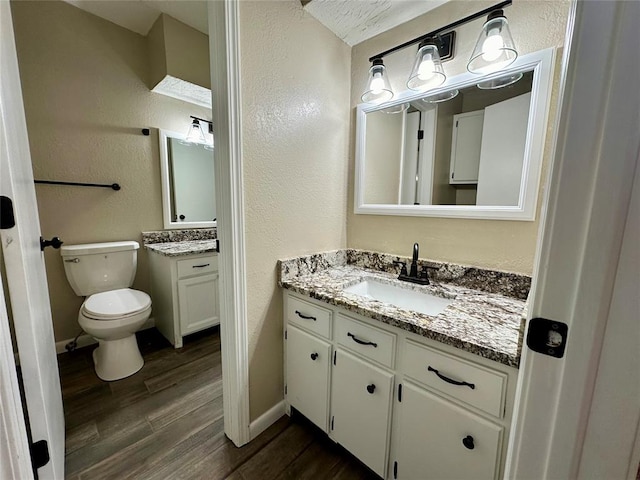 bathroom featuring wood-type flooring, vanity, and toilet