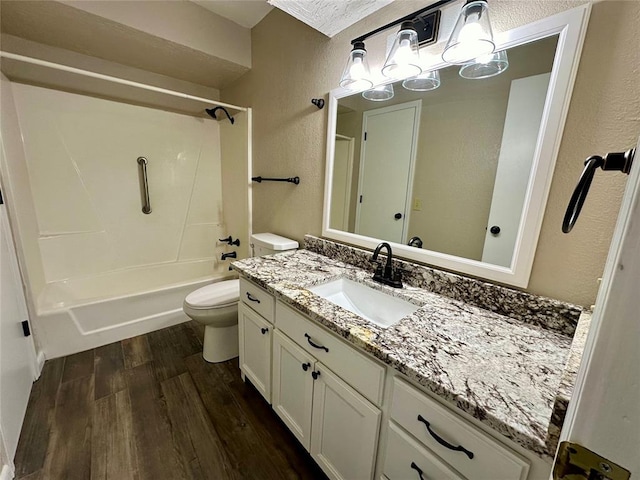 full bathroom with wood-type flooring, a textured ceiling, toilet, shower / washtub combination, and vanity