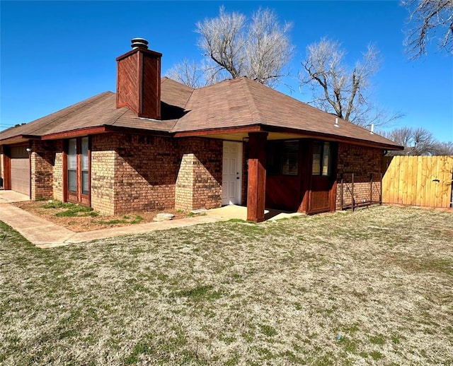 rear view of house with a lawn and a garage