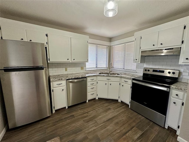 kitchen featuring light stone countertops, dark hardwood / wood-style flooring, stainless steel appliances, sink, and white cabinets