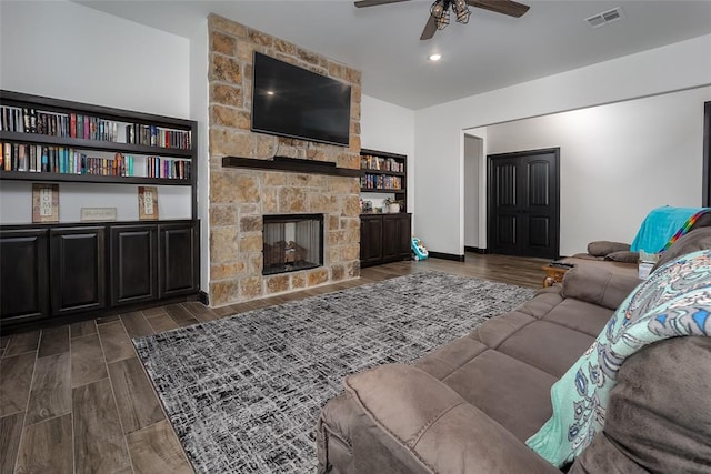 living room featuring ceiling fan and a fireplace