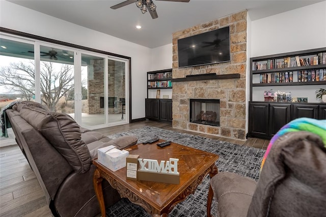 living room with a stone fireplace and light hardwood / wood-style flooring