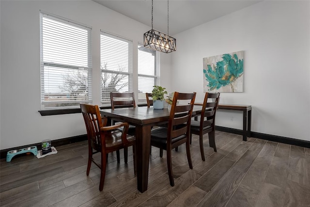 dining space featuring dark hardwood / wood-style flooring and an inviting chandelier