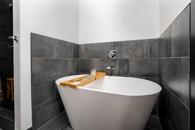 bathroom featuring a bath and tile walls