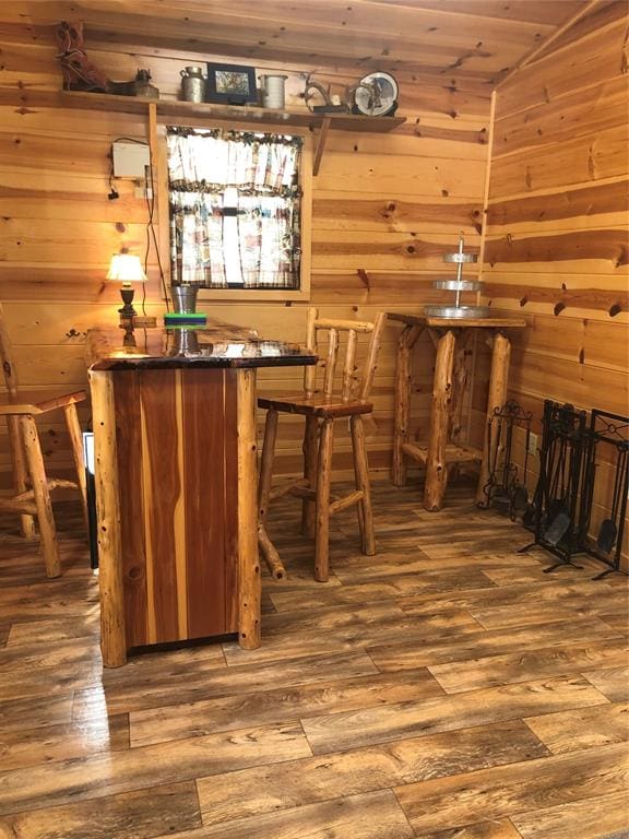 bar featuring wood walls and wood-type flooring