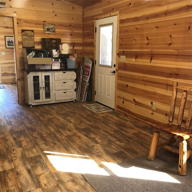 interior space with wood walls, white cabinets, and dark hardwood / wood-style floors