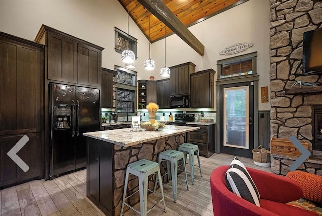 kitchen featuring light stone counters, wood ceiling, black appliances, a center island, and hanging light fixtures