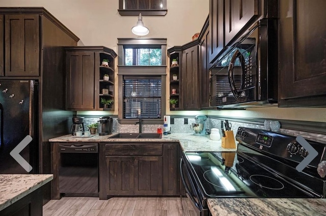 kitchen featuring light stone countertops, dark brown cabinetry, sink, black appliances, and light hardwood / wood-style flooring