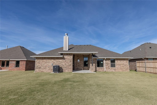 back of property with a lawn, a patio area, and cooling unit