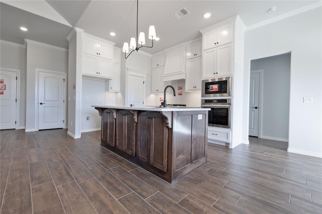 kitchen featuring pendant lighting, a center island with sink, dark hardwood / wood-style floors, and sink