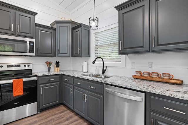 kitchen featuring sink, stainless steel appliances, light stone counters, dark hardwood / wood-style flooring, and vaulted ceiling