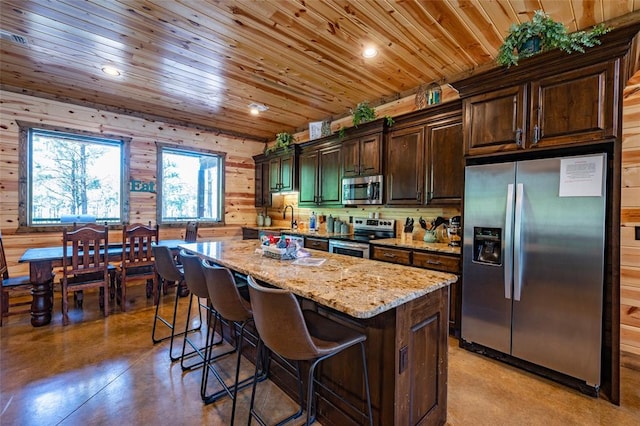 kitchen with stainless steel appliances, dark brown cabinetry, light stone countertops, a kitchen island, and wooden ceiling