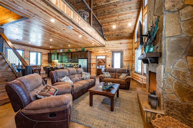 living room with a stone fireplace, wooden walls, wood ceiling, and high vaulted ceiling