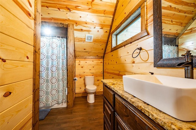 bathroom featuring wooden walls, toilet, and vaulted ceiling